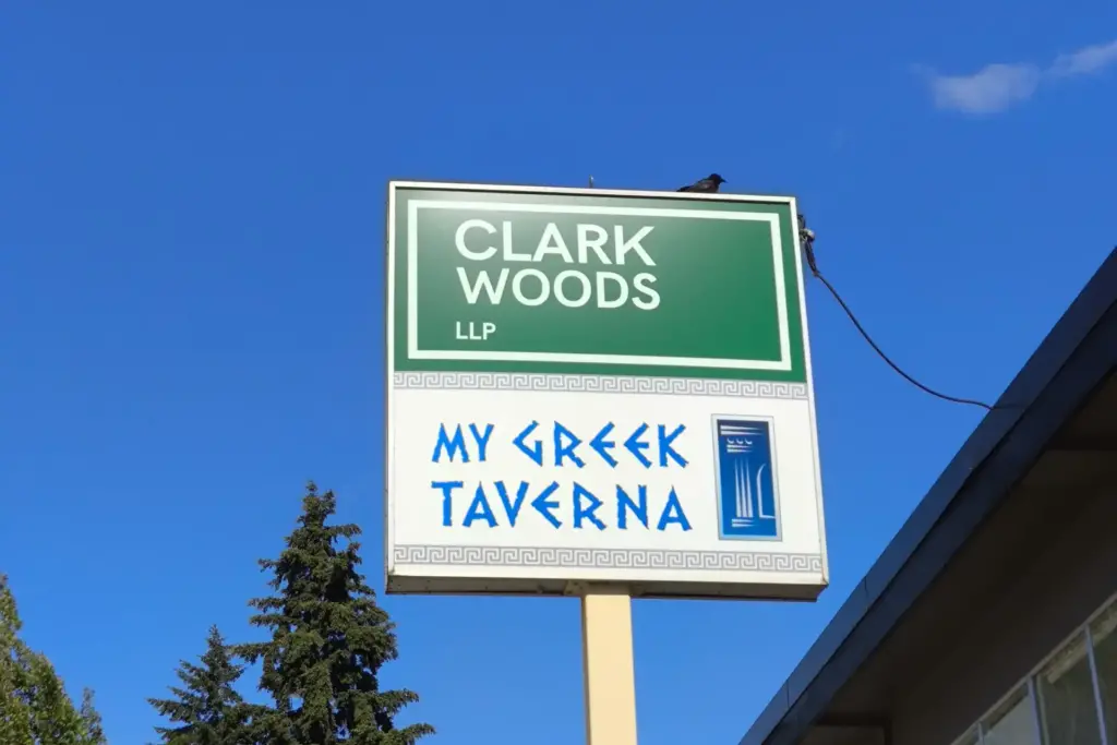 A pylon sign with two businesses displayed, one of an accountant and one of a restaurant