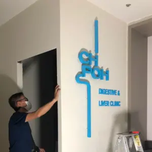 Interior of office undergoing renovation with a blue sign installed on wall